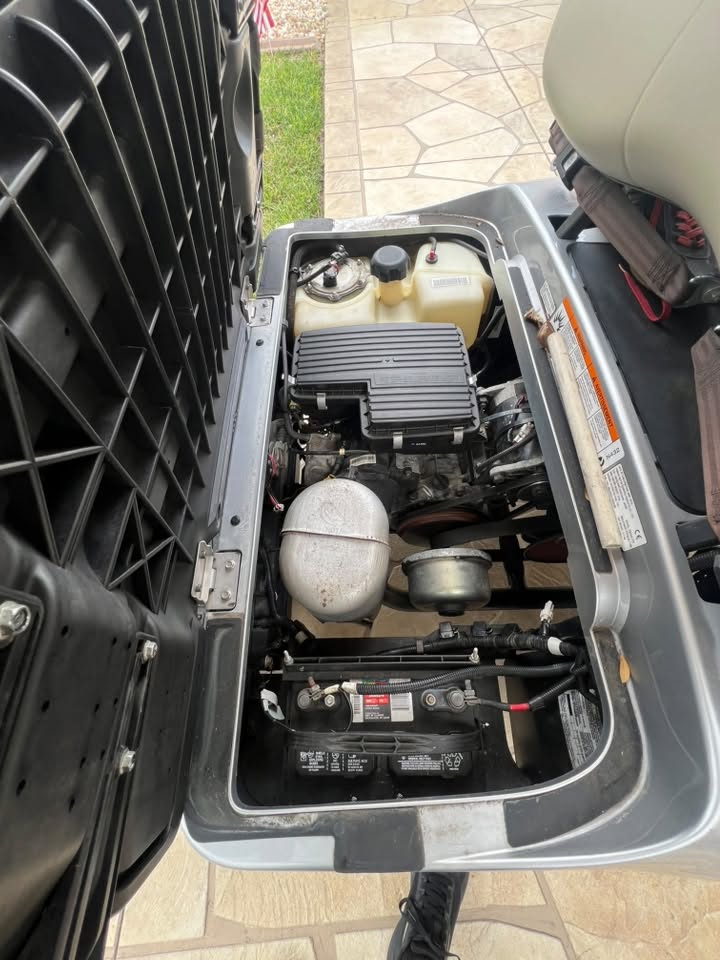 Open golf cart engine bay showing the battery and drivetrain during service